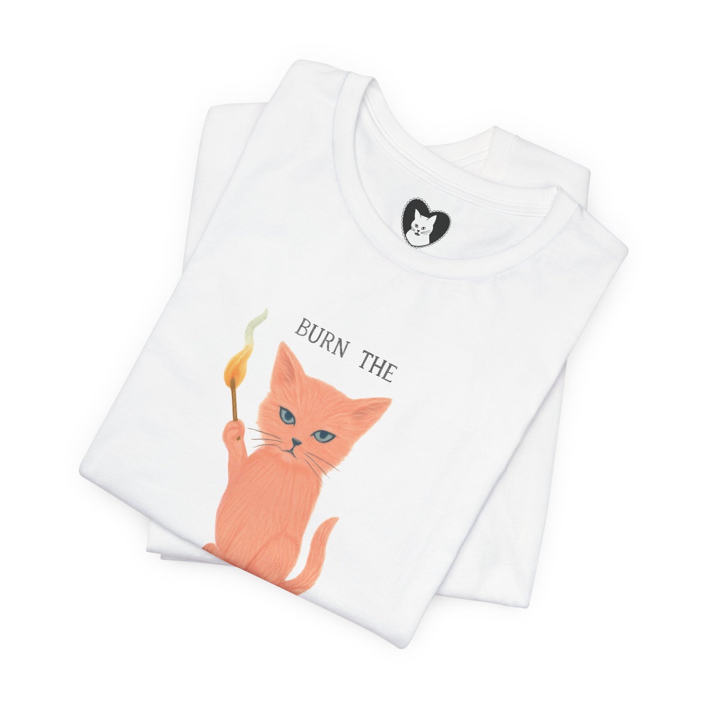 Flatlay of pink feminist tee with bold illustrated cat design